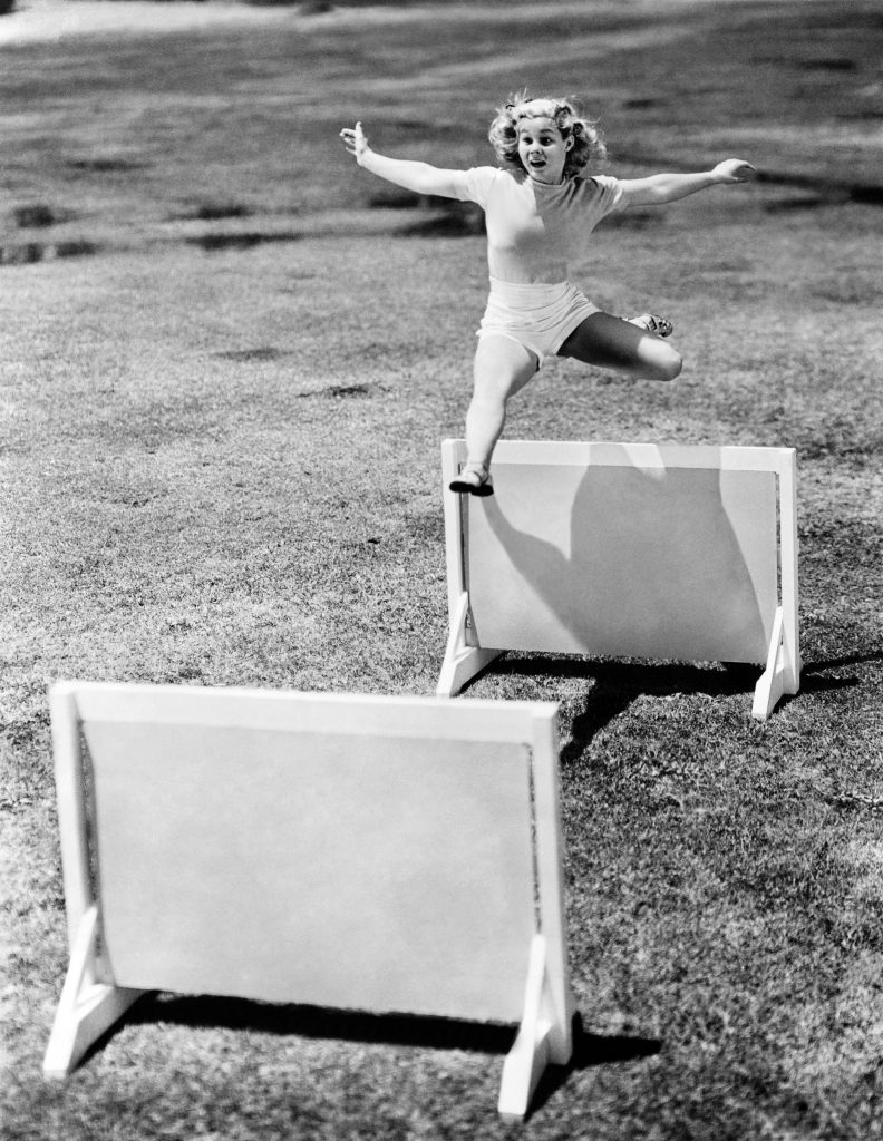 Woman jumping hurdles labeled with years